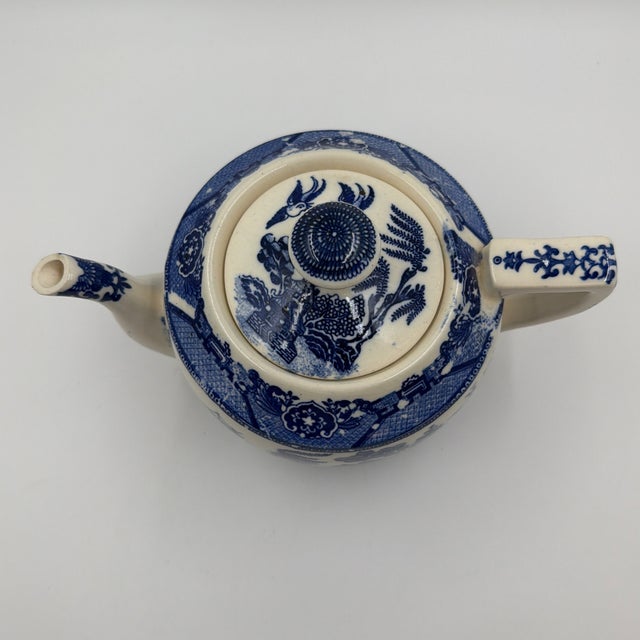 Charming vintage Japanese blue and white teapot featuring a classic Willow-style landscape rendered in deep cobalt blue...