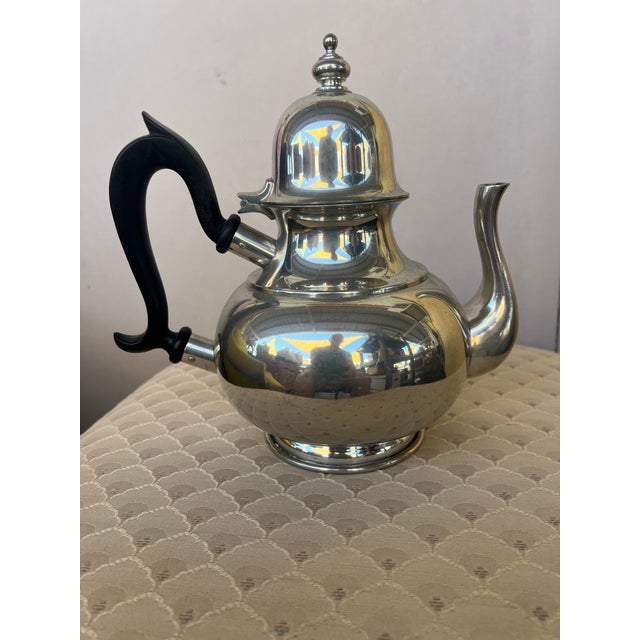 This is a vintage 1980s Kirk Stieff "Old Annapolis" pewter teapot featuring a polished finish and a distinct black handle....