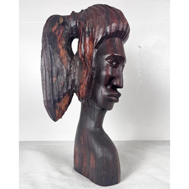Vintage primitive carved wood bust of a woman her hair up in a ponytail. Dark wood with natural variations throughout.