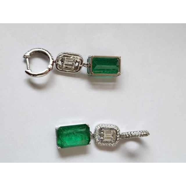 A very beautiful and useful, Emerald Dangle Earring set in 18K white Gold & Diamonds. The weight of the Emeralds is 17.57...