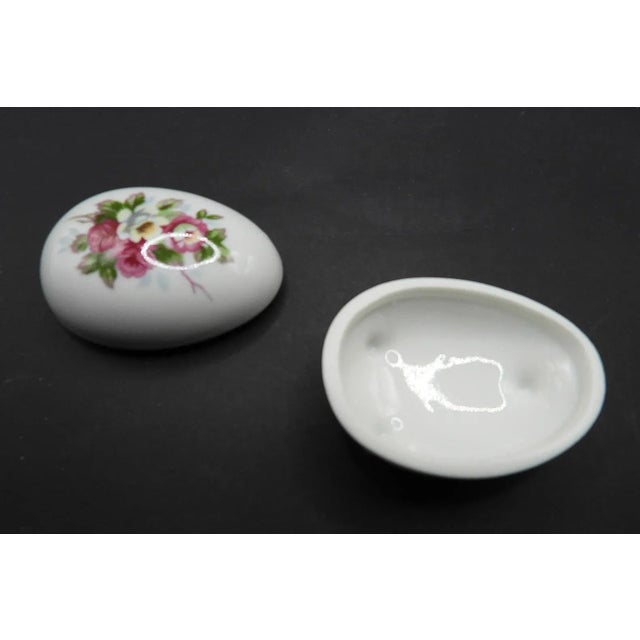 This darling 1950s style egg shaped trinket or ring box is created in gorgeous white glossy porcelain with a beautiful...