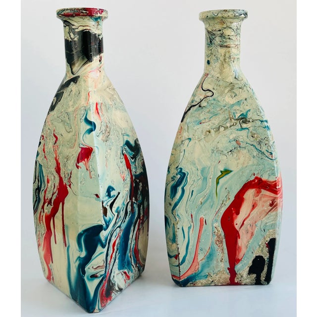 These 1950's clear glass liquor decanters are coated with a matching faux marble finish in patriotic red, white and blue...