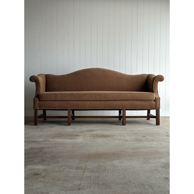 Vintage camelback sofa with shaped crest rail and tailored rolled arms. Soft brown woven upholstery raised on an exposed...
