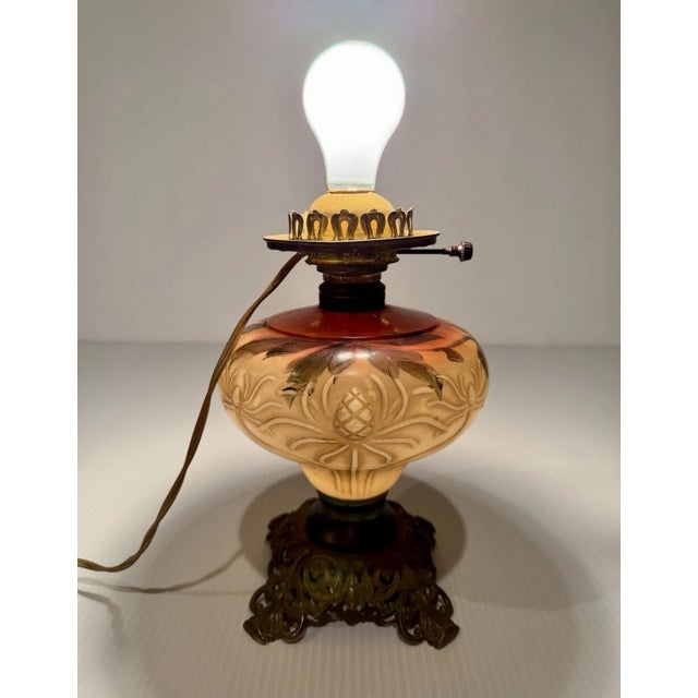 An antique brass oil lamp, converted to electric, with a handpainted glass middle. Looks particularly lovely with the...