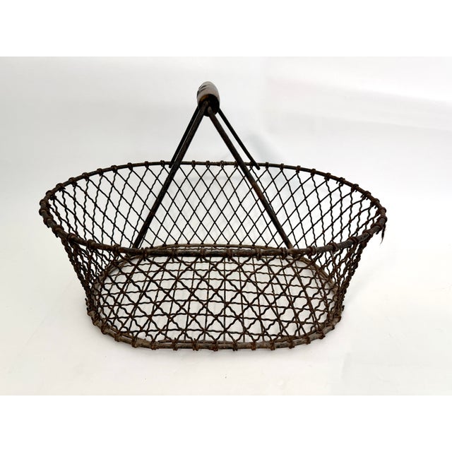 This is a vintage French wire basket with fixed wood grip handle used for harvesting or gathering eggs, fruit, pr...