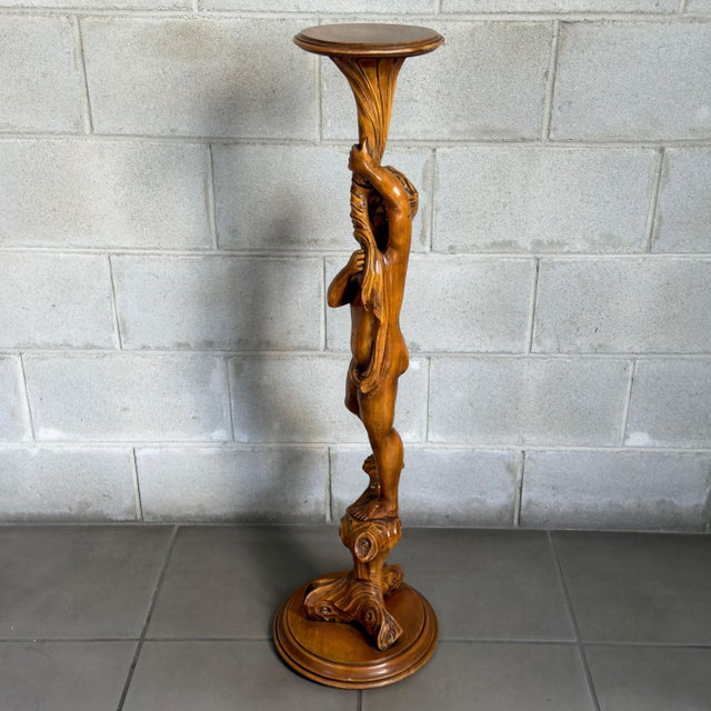 A dramatic and slender, full-length floor-standing planter column in finely hand-carved solid wood, a refined creation of...