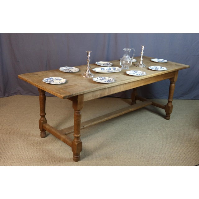 Mid-20th century oak dining table. The four legs are joined by a stretcher. Good condition. Signs of wear on the tabletop....