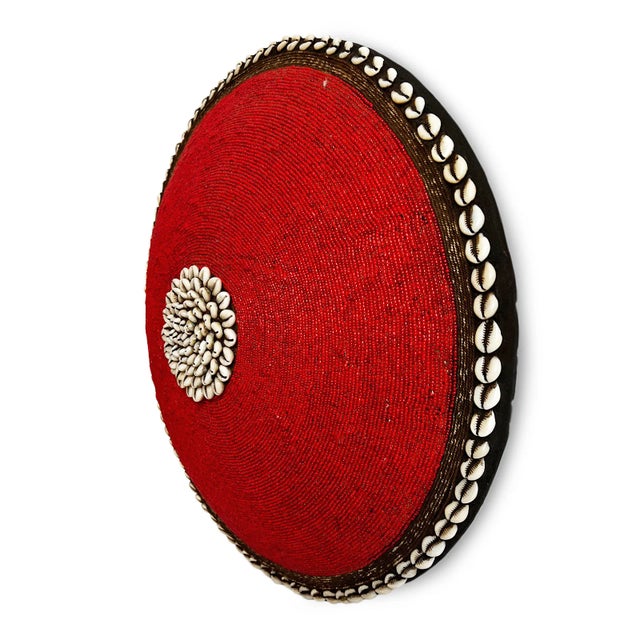 Striking vintage red hand beaded shield with cowry shell border and center. Wooden shield as base. Makes for beautiful...