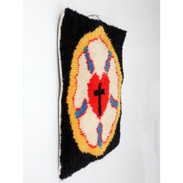 A mid century folk art textile wall hanging featuring the luther rose motif in saturated red, blue, cream, yellow, and...