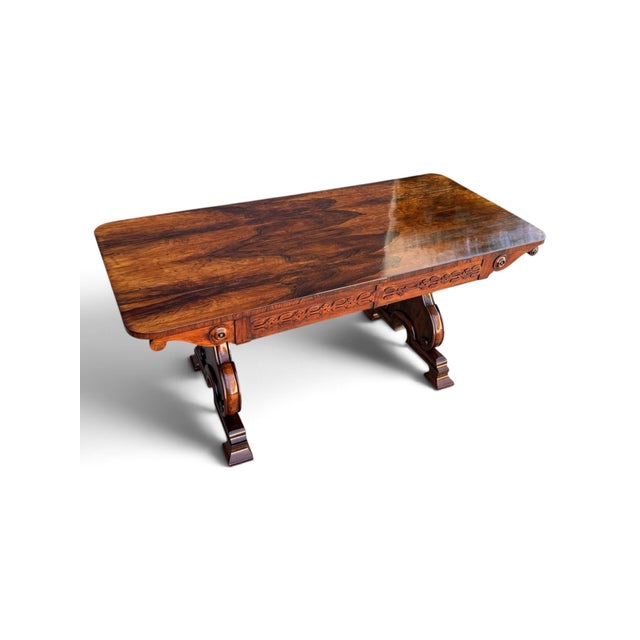 A fine English Regency-period sofa table or partners desk crafted in richly figured rosewood. The broad rectangular top...