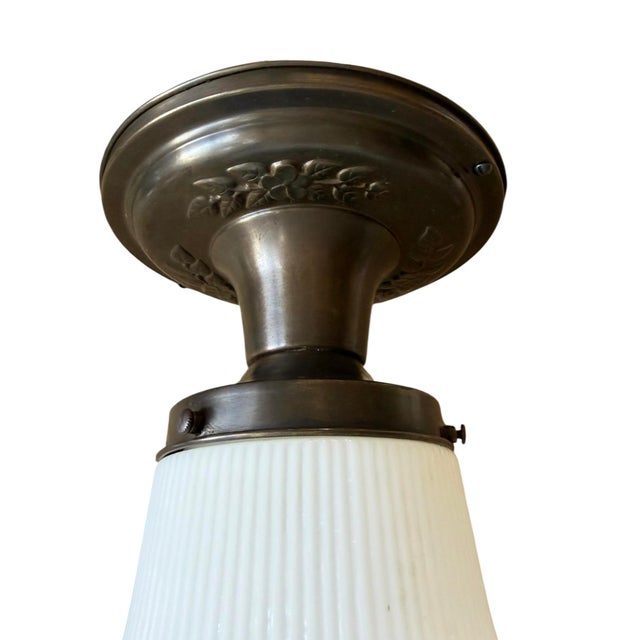 Great 1920’s flush mount ceiling light with a ribbed milk glass shade and a dark bronze finish canopy. Great floral motif...