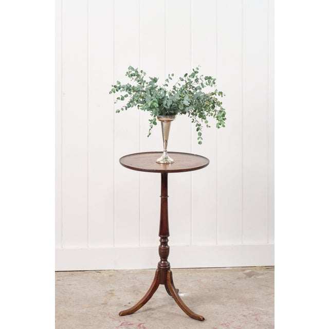 This antique Georgian walnut wine table showcases a rich, aged patina with subtle grain variations. The turned pedestal...