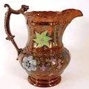 An antique copper buster jug with enamel floral decoration and a figural dog handle thumb rest. STYLE Victorian COLOR(S)...