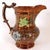 An antique copper buster jug with enamel floral decoration and a figural dog handle thumb rest. STYLE Victorian COLOR(S)...