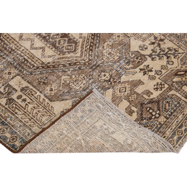 Beautiful vintage Persian distressed hand-knotted wool rug with a beige color field. This piece has a gray frame and brown...