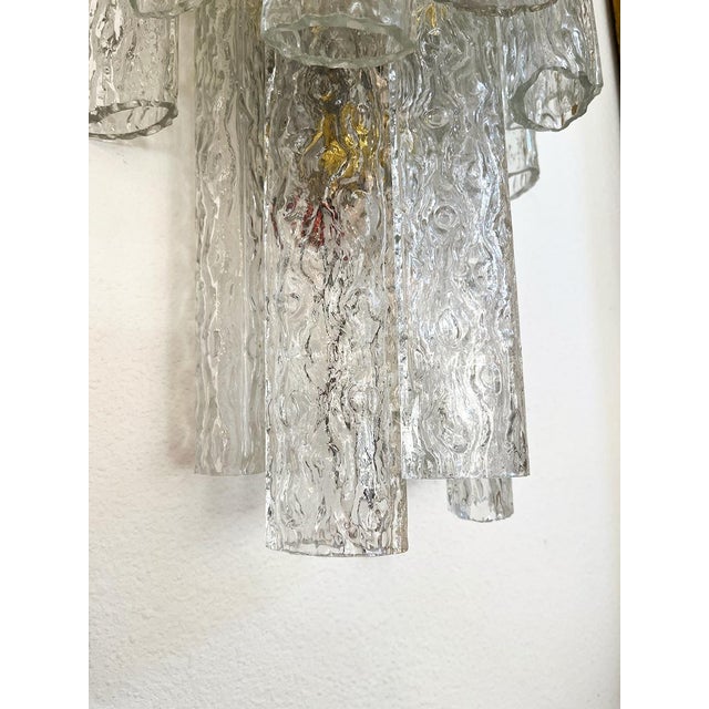 These sconces are crafted from authentic Italian Murano glass. They are tubular in shape and refract the light beautifully.