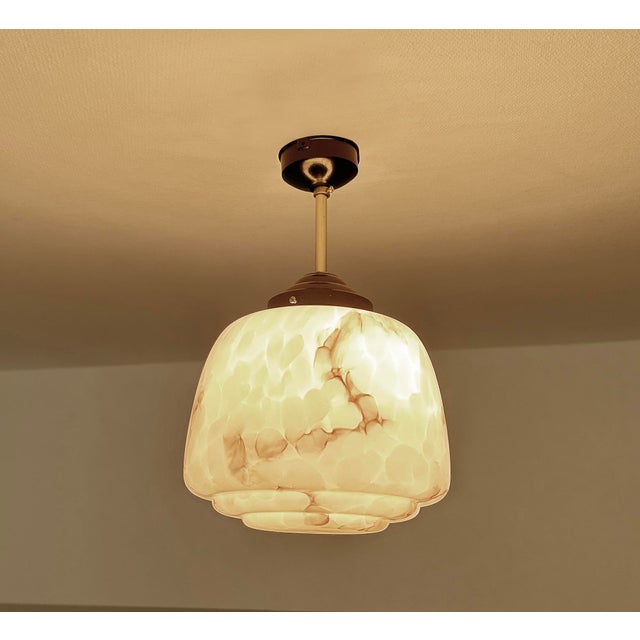 Art Deco pendant lamp from the 1930s, stepped Ivory glass shade mounted on a brass and bakelite suspension, the bakelite...