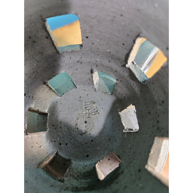 This is a handmade gray pottery pedestal-bowl with loop handles, pierced pedestal base, and is most likely a 20th century...