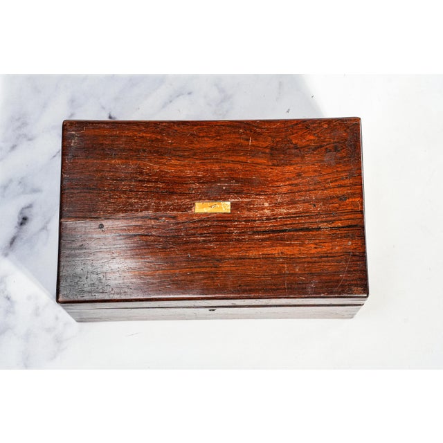 A charming example of mid-19th century craftsmanship, this handsome antique jewelry box dates to circa 1850 and is...