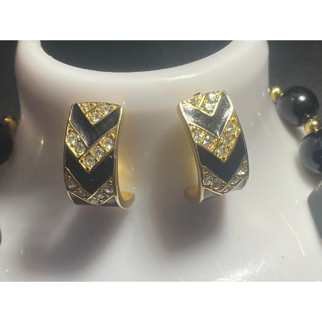 This vintage 1980s Trifari demi-parure features 18” necklace and earrings in a bold Art Deco revival aesthetic, pairing a...