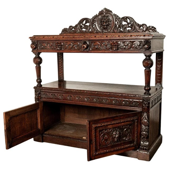 A fine antique Scottish Renaissance Revival carved oak server/ buffet, circa 1860. This sumptuously carved buffet with a...