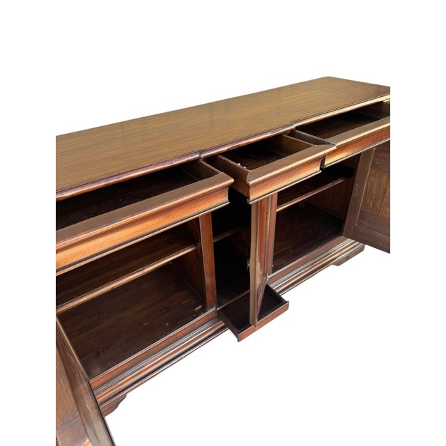 Elegant vintage sideboard featuring richly figured wood with decorative inlaid panel doors. The case offers generous...