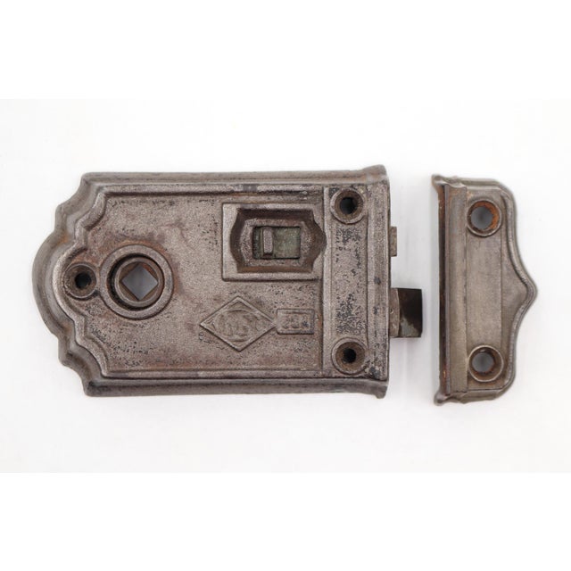 Antique cast iron rim lock with a working lock latch. The surface was painted silver or gray. Made by Russell & Erwin. The...