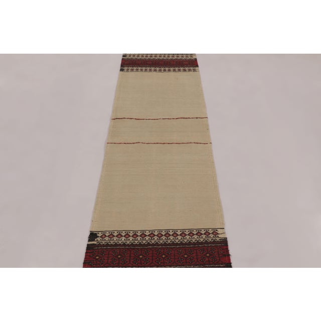 Made with handwoven wool circa 1950-1960, this 2x10 vintage flat-weave runner Kilim is a particularly unique and sought-...