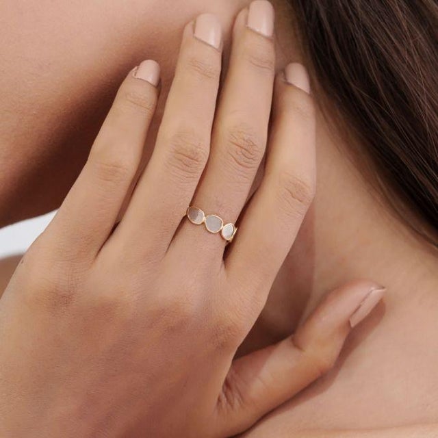 This elegant band ring features a 1.1 ct, mixed-shape natural diamond, set in 18k yellow gold. Each is securely framed in...