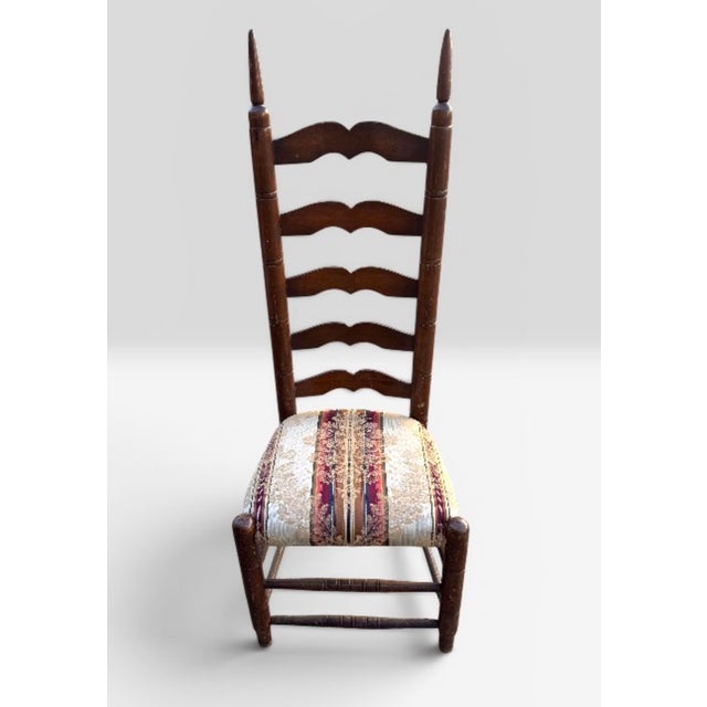 A high-backed ladderback chair featuring five arched horizontal slats and an upholstered drop-in seat. The ladderback...