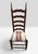 A high-backed ladderback chair featuring five arched horizontal slats and an upholstered drop-in seat. The ladderback...