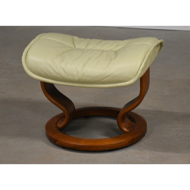 An Ekornes Stressless ottoman with off white beige cream leather and a teak base made for the reclining lounge chair....