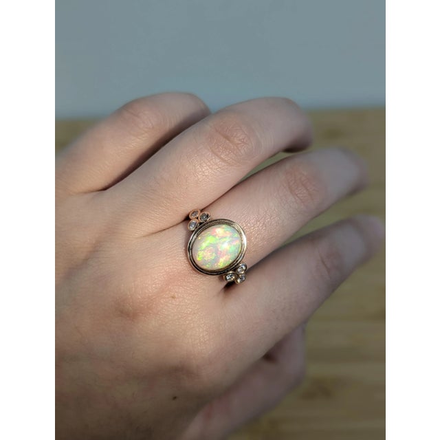 This dreamy oval opal ring glows with iridescent color, set in 14K solid rose gold and accented with natural diamonds for...