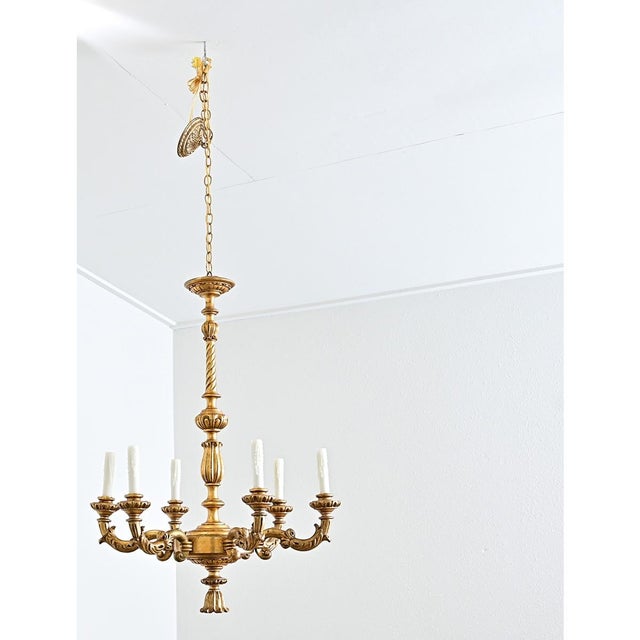 A glorious six-light Neoclassical giltwood chandelier from 19th century France. This beautiful antique fixture is made of...