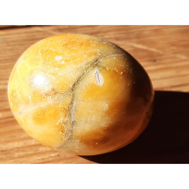 An exquisite mid-century decorative marble egg that stands out with its stunning golden, yellow with hints of amber hue!...