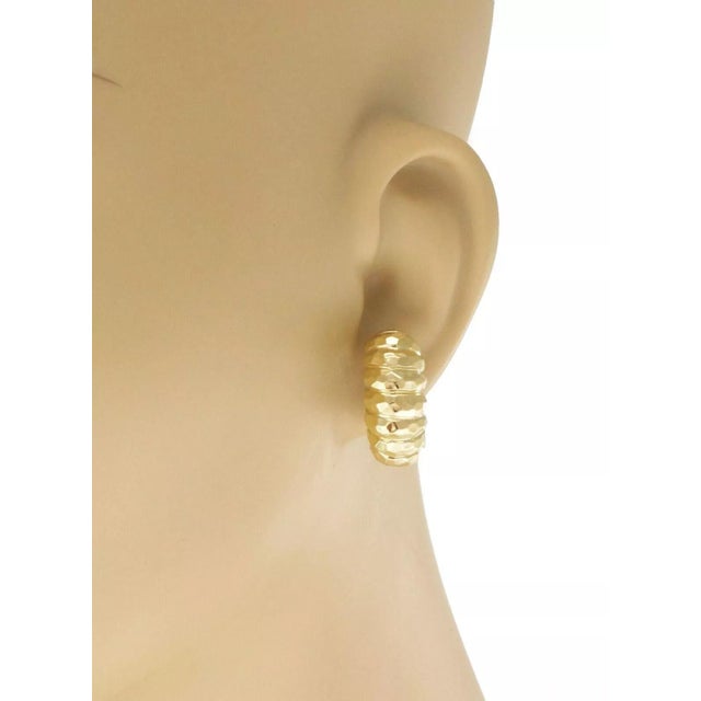This is a pair of authentic huggie earrings by designer Henry Dunay, they are crafted from 18k yellow gold featuring the...