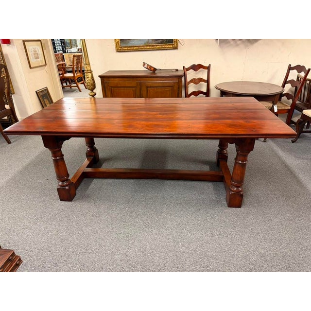 Mahogany English Country Rustic Farmhouse dining table featuring a large plank-top surface with traditional peg...