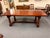 Mahogany English Country Rustic Farmhouse dining table featuring a large plank-top surface with traditional peg...
