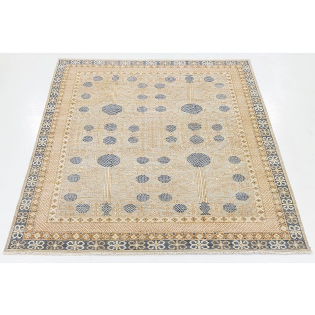 This Khotan-style hand-knotted wool rug features a soft Mist Gray background, beautifully accented by delicate touches of...