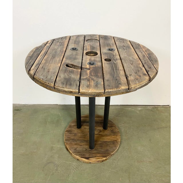 Vintage Industrial circle coffee table from the 1960s. It features black iron legs and a solid wooden surface with very...
