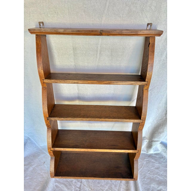 This Early 20th Century Wall Shelf was handcrafted from old growth oak in the early 1900's. The piece features gracefully...