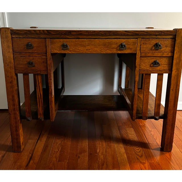 Antique early 1900’s mission style oak writing desk by Bourn & Hadley Co. features five drawers and book shelves on either...