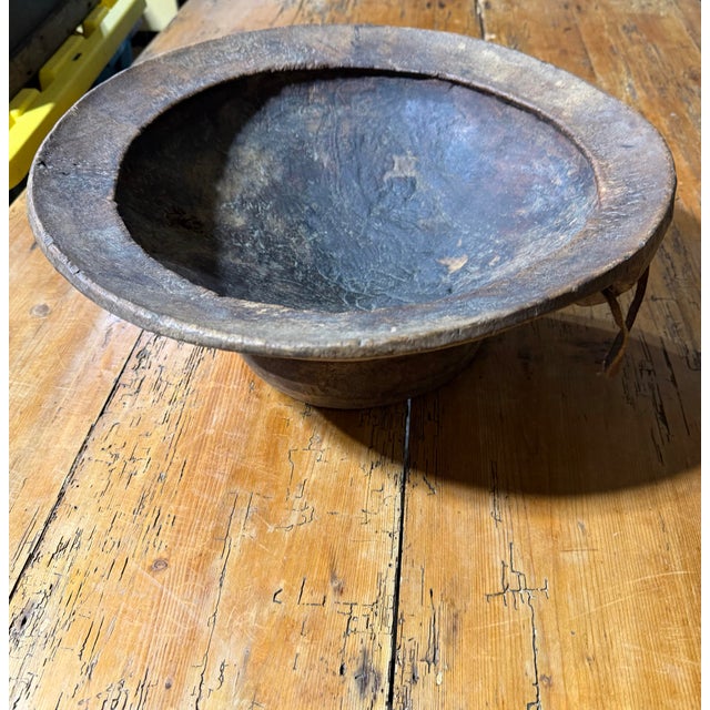 An exceptional antique-style primitive wooden bowl, beautifully hand-carved with a substantial circular form, deeply...