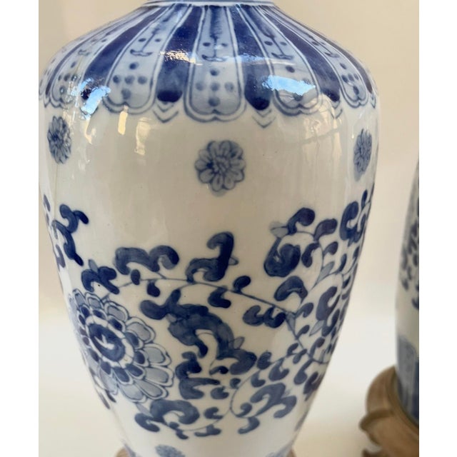 Classic pair of blue and white hand-painted floral and geometric patterned designer table lamps mounted on ornate Asian...
