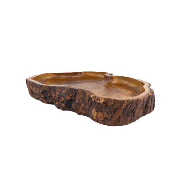 A striking hand-carved olive wood serving tray, crafted from a single piece of wood and finished with a natural live edge....