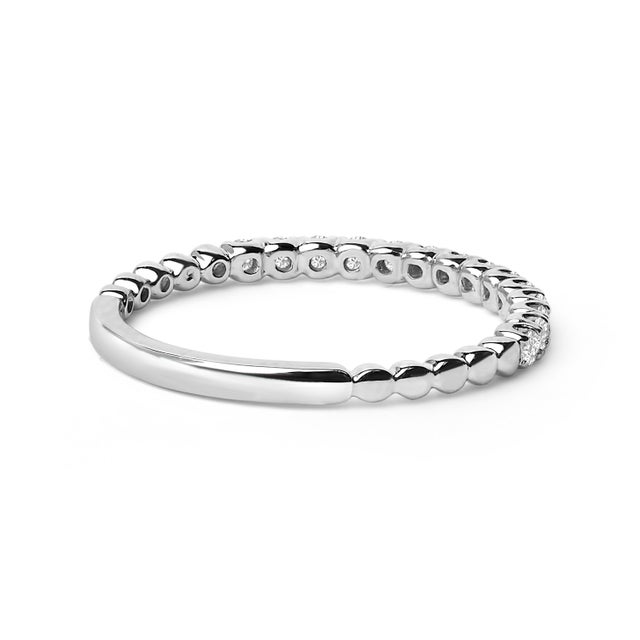 Immerse yourself in the effortless elegance of this exquisite wedding band, masterfully crafted from 14K white gold with a...