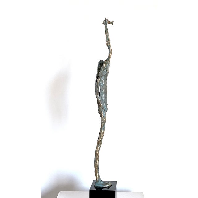 The last Fisherman: Slender and upright, the figure appears on the dark granite base like a creature between human and...