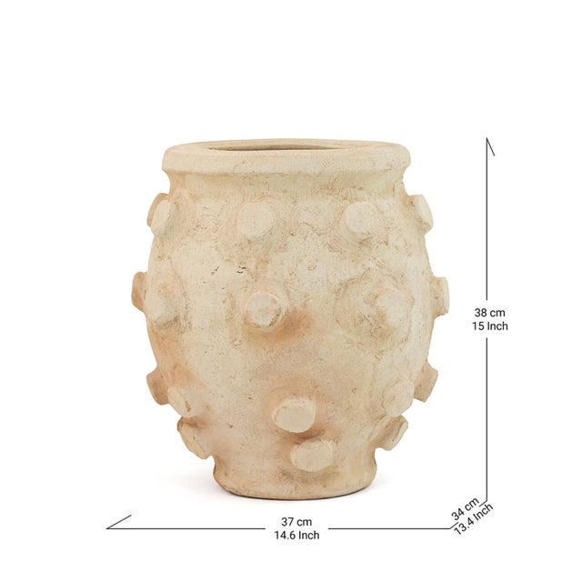 Rounded relief studs press outward across the full circumference of this Tamegroute pot, its soft white surface warmed by...