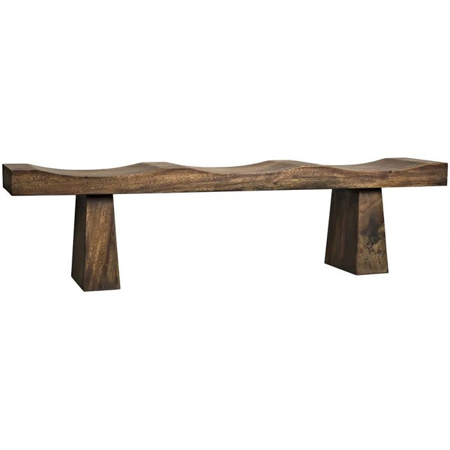Expertly hand-hewn from munggur wood, this contemporary bench has an Eastern aesthetic and a natural finish.
