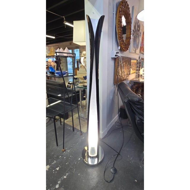 Wonderful and whimsical floor lamp is made from curved fiberglass with a black exterior and white interior and a chrome...